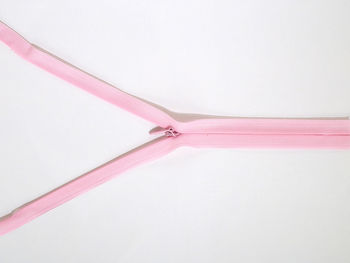 Close-up of pink zipper against white background