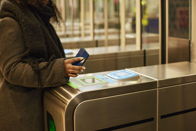 Woman paying for subway ticket with smart phone