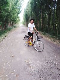 Young man riding bicycle on road