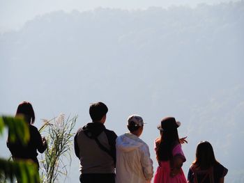 Rear view of woman standing against sky