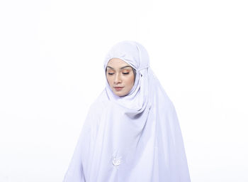 Portrait of beautiful young woman against white background