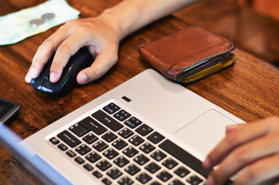 Midsection of man using laptop on table