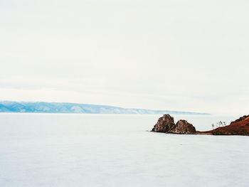 Scenic view of sea and mountains against sky