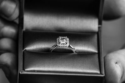 Close-up of hand holding wedding ring in jewelry box