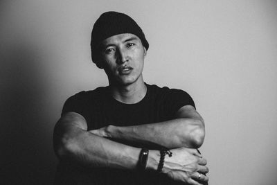 Portrait of young man standing against wall