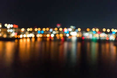 Defocused image of illuminated lights in city at night