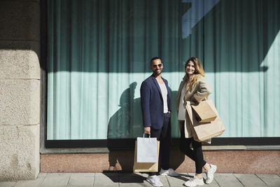 Friends standing on sidewalk with shopping bags