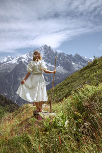 Rear view of woman on mountain against sky