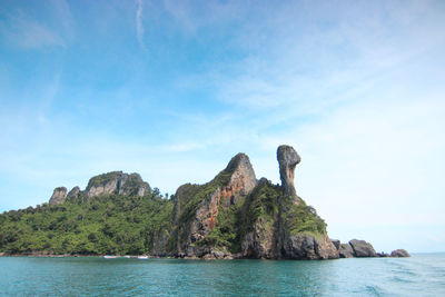 Rock formations by sea against sky