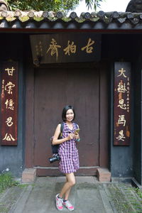 Portrait of woman standing against closed door