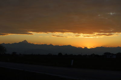 Scenic view of silhouette mountains against orange sky