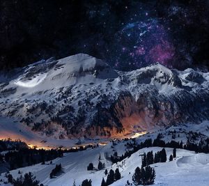 Scenic view of snow covered mountains against sky at night