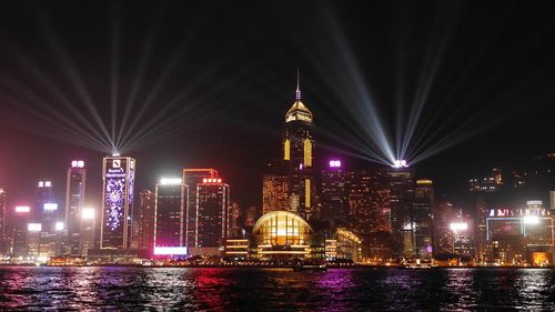 Illuminated buildings by river at night