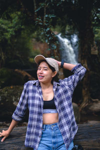 Portrait of woman standing against trees