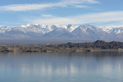 Scenic view of lake and snowcapped mountains against sky