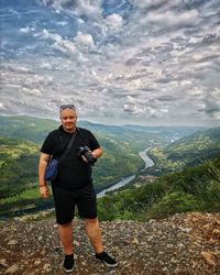 Full length of man standing on mountain against sky