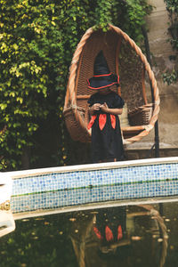 Girl wearing witch costume standing at poolside in back yard