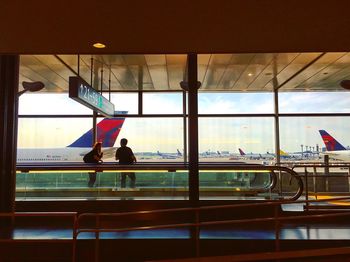 People at airport against sky in city