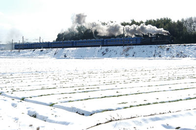 Snow covered field against sky