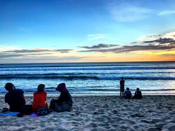 Rear view of people sitting on beach