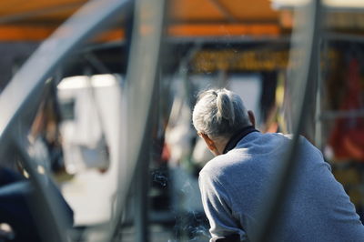 Rear view of man skateboarding on bus