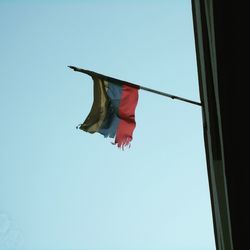 Low angle view of american flag against clear blue sky