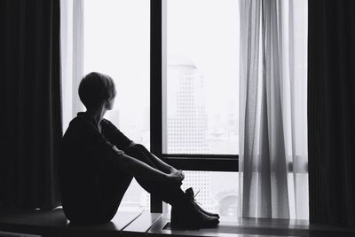 Woman sitting by window at home