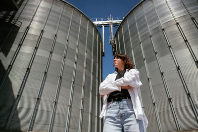 Low angle view of young woman standing in city