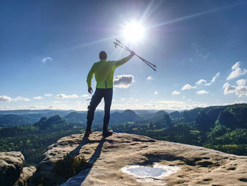 Trekking poles in  air open mountain valley bellow cliff. silhouette of tourist with poles in hands