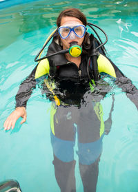 Portrait of woman with aqualung swimming in pool