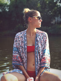 Young woman looking away while sitting in boat