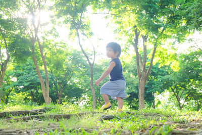 Full length of boy looking away on tree