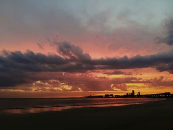 Scenic view of sea against dramatic sky during sunset