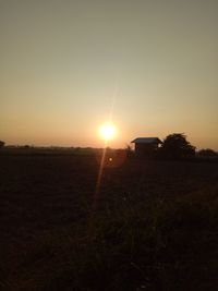 Scenic view of field against clear sky during sunset