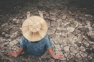 High angle view of girl sitting on drought field
