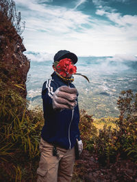 Man standing by plants against sky during winter