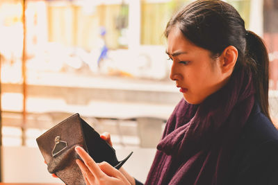 Close-up portrait of young woman holding book