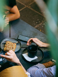 Midsection of woman holding coffee cup on table