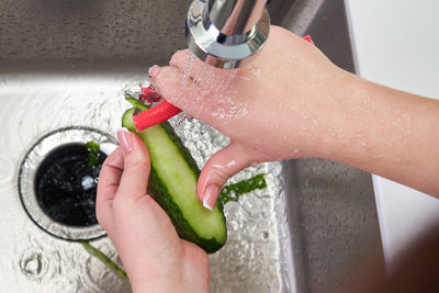 Cropped image of hand holding wet glass at home