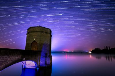 Illuminated tower against sky at night