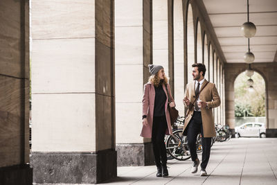 Business people talking while walking in corridor