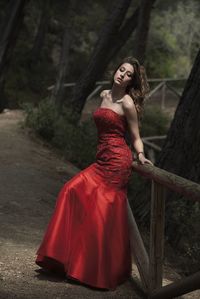 Young woman looking away while standing on tree