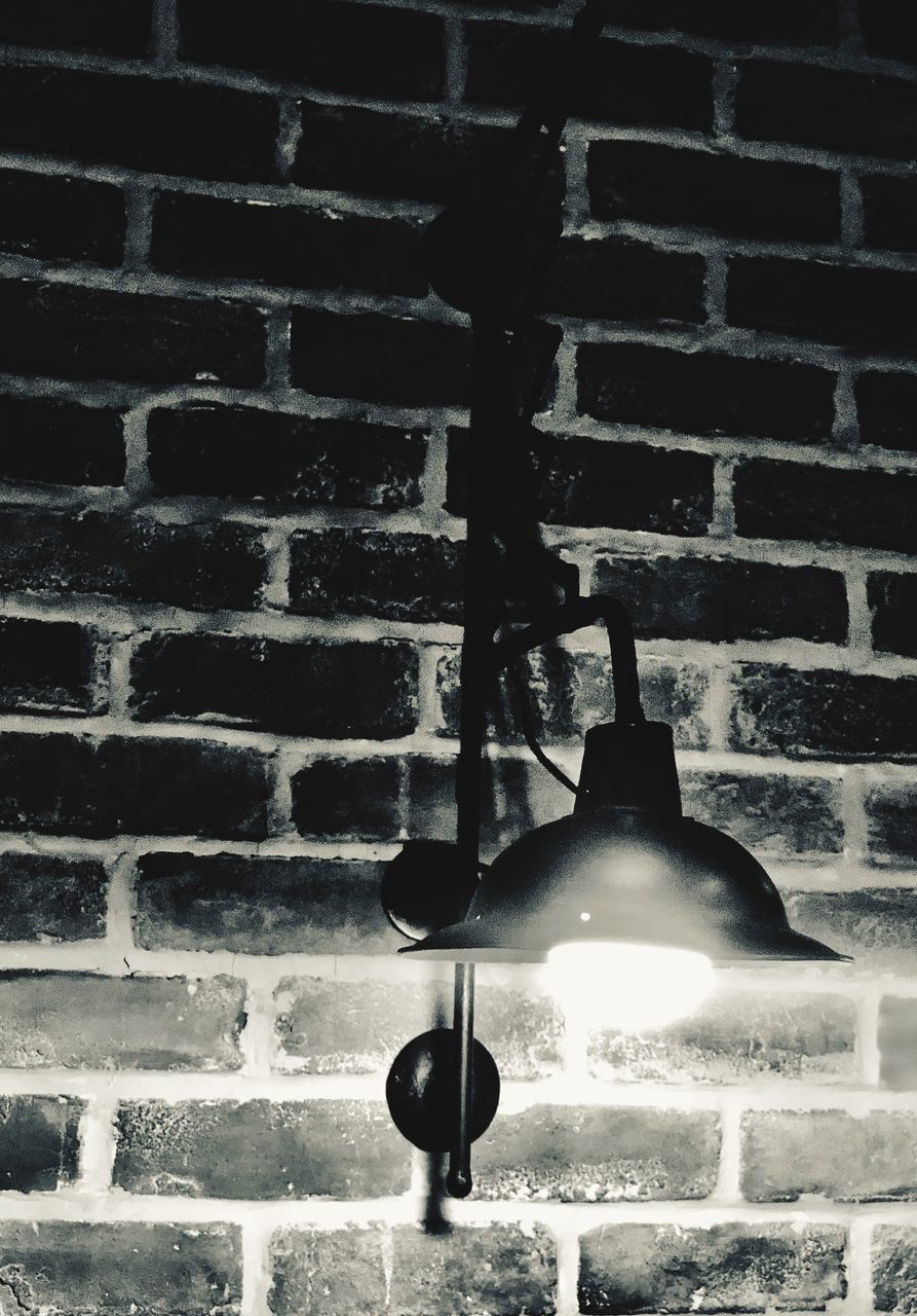 LOW ANGLE VIEW OF ILLUMINATED LAMP ON WALL