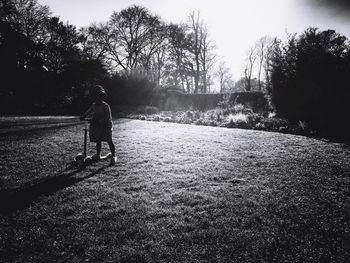 Rear view of girl walking on grass