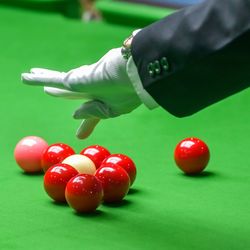 Cropped hand playing pool at table