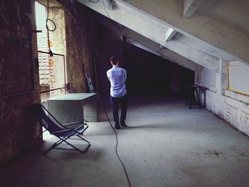 Rear view of man in abandoned old room