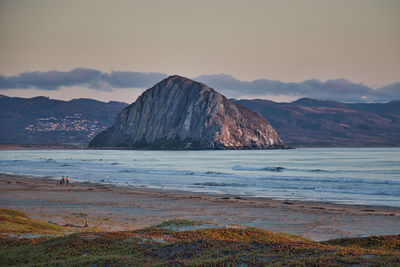 Scenic view of sea and mountains against sky during sunset