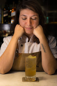 Woman with drink on table sitting in restaurant