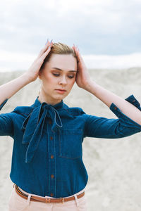 Fashion beauty portrait of young woman in blue organic denim shirt on desert background