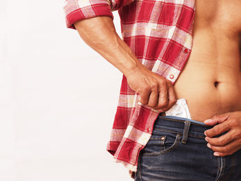 Midsection of woman holding hands against white background